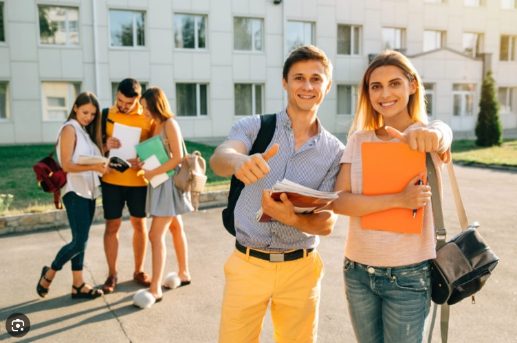 Studenti con il pollice in sù davanti lo studentato